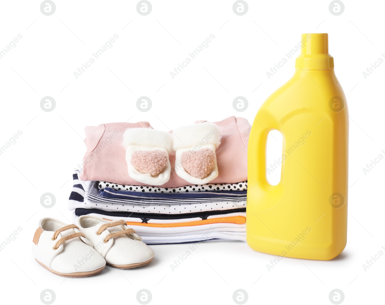 Bottle with fabric softener, shoes and baby clothes isolated on white Photo of Bottle with fabric softener, shoes and baby clothes isolated on white