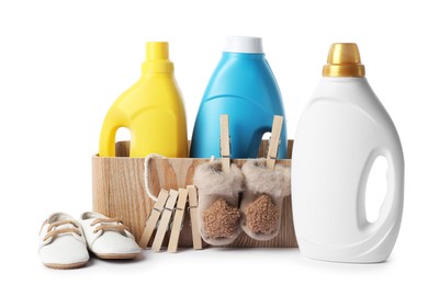 Photo of Bottles with fabric softener, basket, shoes and clothespins isolated on white