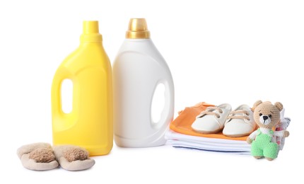 Photo of Bottles with fabric softener, shoes, baby clothes and toy isolated on white
