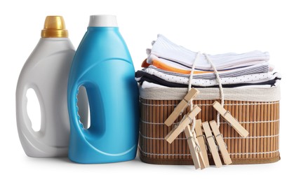 Photo of Bottles with fabric softener, basket, baby clothes and clothespins isolated on white
