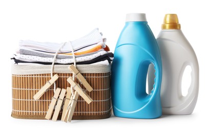 Photo of Bottles with fabric softener, basket, baby clothes and clothespins isolated on white