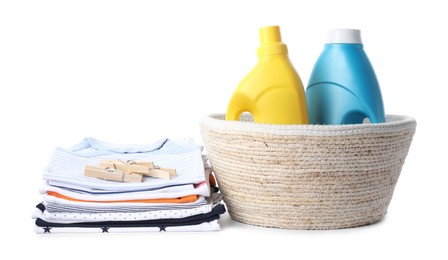 Photo of Bottles with fabric softener, basket, baby clothes and clothespins isolated on white