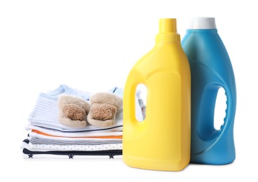 Photo of Bottles with fabric softener, shoes and baby clothes isolated on white