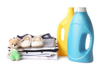 Photo of Bottles with fabric softener, shoes, baby clothes and toy isolated on white