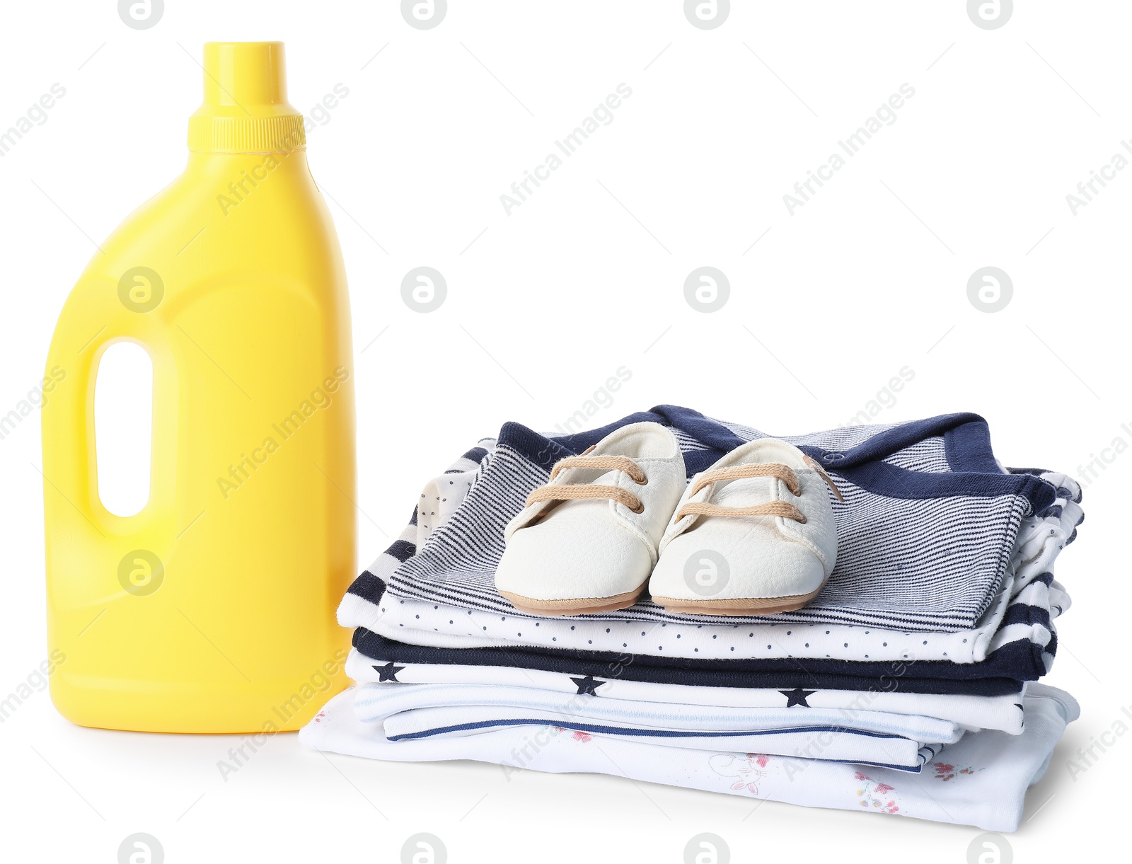 Bottle with fabric softener, shoes and baby clothes isolated on white Photo of Bottle with fabric softener, shoes and baby clothes isolated on white