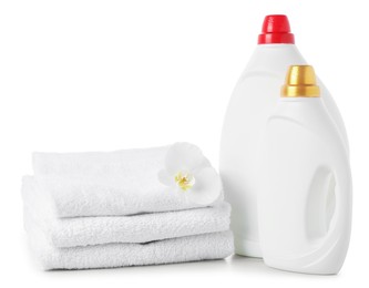 Photo of Bottles of fabric softener, stacked towels and flower isolated on white