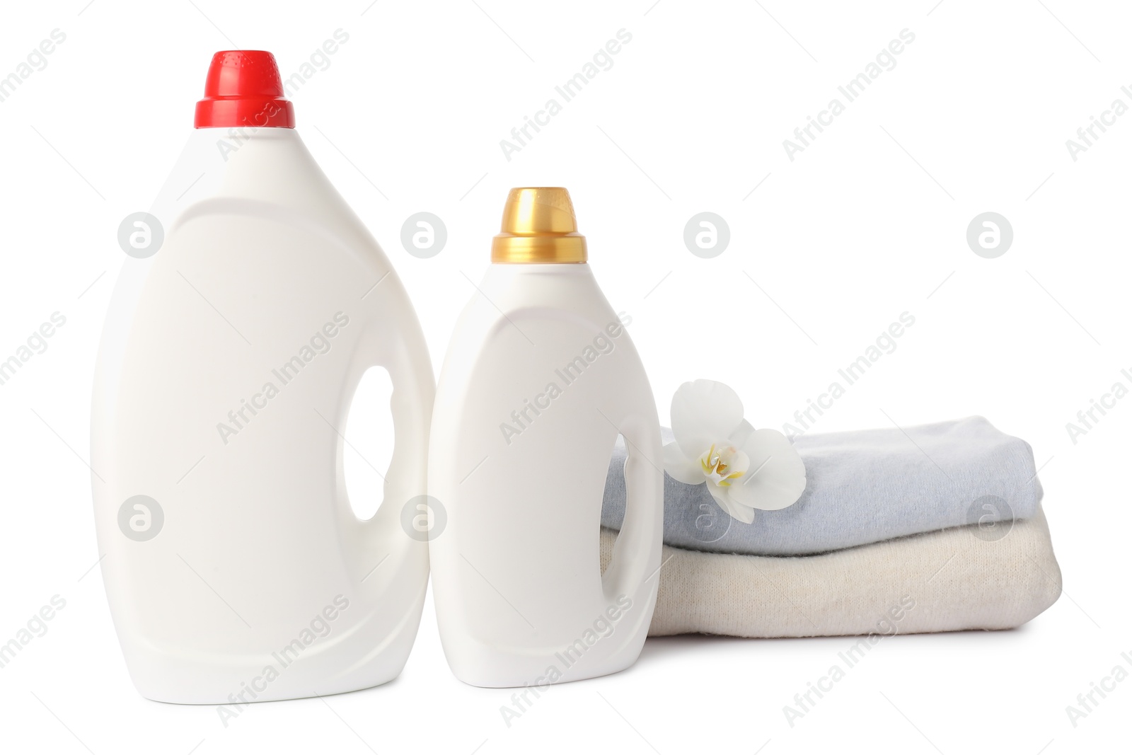 Photo of Bottles of fabric softener, stacked clothes and flower isolated on white