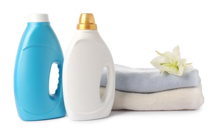 Photo of Bottles of fabric softener, stacked clothes and flower isolated on white