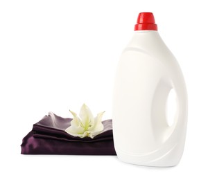 Photo of Bottle of fabric softener, stacked clothes and flower isolated on white
