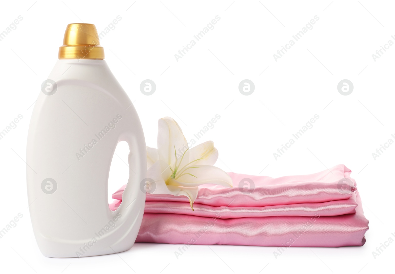 Bottle of fabric softener, stacked clothes and flower isolated on white Photo of Bottle of fabric softener, stacked clothes and flower isolated on white
