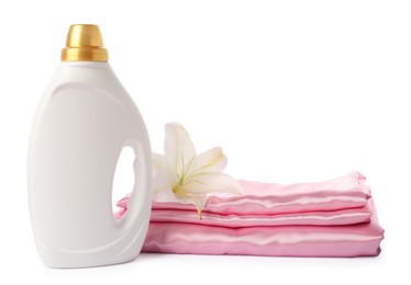 Photo of Bottle of fabric softener, stacked clothes and flower isolated on white