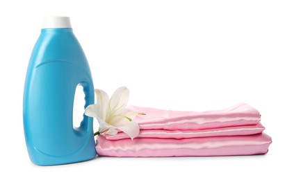 Photo of Bottle of fabric softener, stacked clothes and flower isolated on white