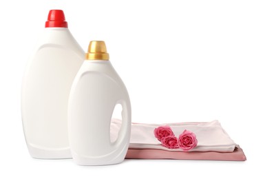 Photo of Bottles of fabric softener, stacked clothes and flowers isolated on white