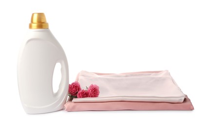 Photo of Bottle of fabric softener, stacked clothes and flowers isolated on white