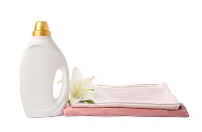 Photo of Bottle of fabric softener, stacked clothes and flower isolated on white
