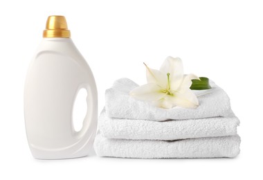 Photo of Bottle of fabric softener, stacked towels and flower isolated on white