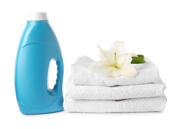 Photo of Bottle of fabric softener, stacked towels and flower isolated on white