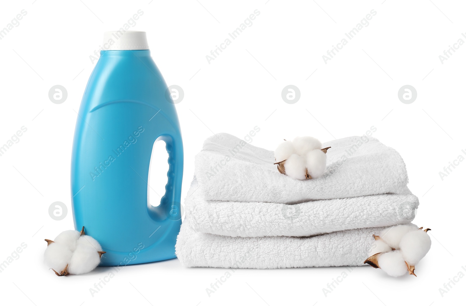 Bottle of fabric softener, stacked towels and cotton flowers isolated on white Photo of Bottle of fabric softener, stacked towels and cotton flowers isolated on white