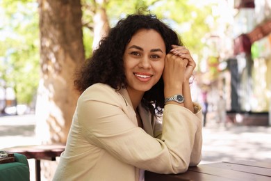 Photo of Portrait of smiling Latin American woman in outdoor cafe