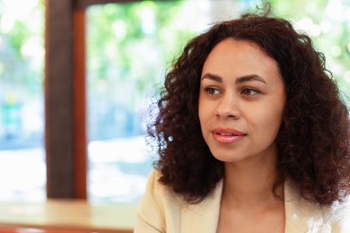 Photo of Portrait of beautiful Latin American woman in cafe. Space for text