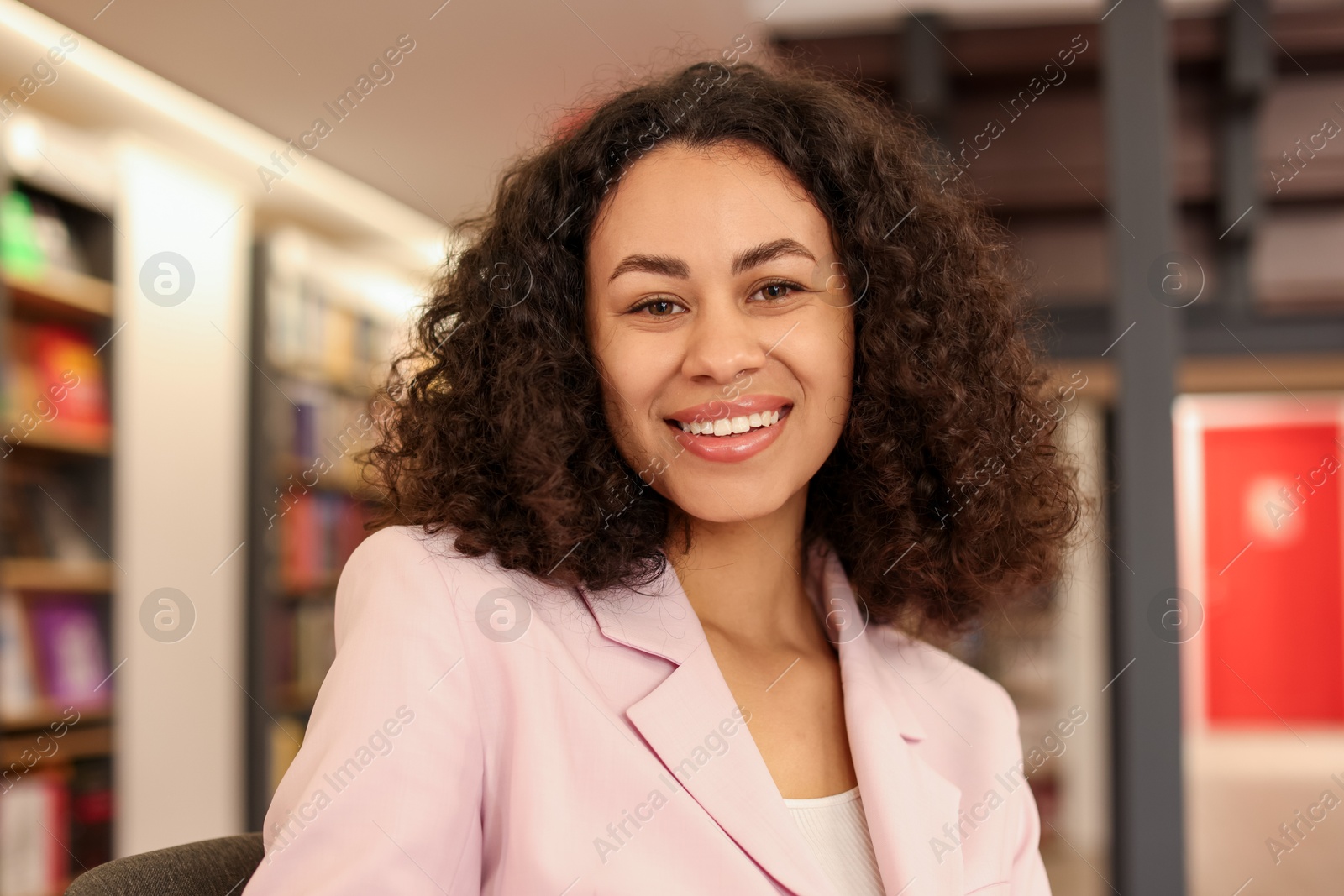 Portrait of smiling Latin American woman in bookshop Photo of Portrait of smiling Latin American woman in bookshop