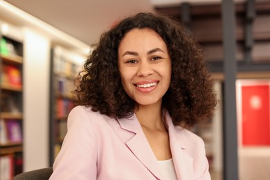 Photo of Portrait of smiling Latin American woman in bookshop
