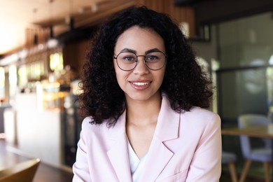 Photo of Portrait of smiling Latin American woman in cafe