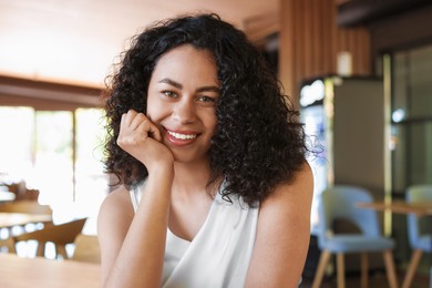 Photo of Portrait of smiling Latin American woman in cafe