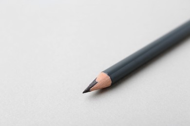 Photo of Grey eyebrow pencil on light background, closeup. Space for text