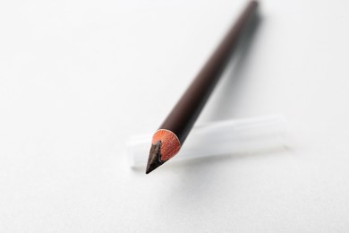 Photo of Brown eyebrow pencil on light background, closeup