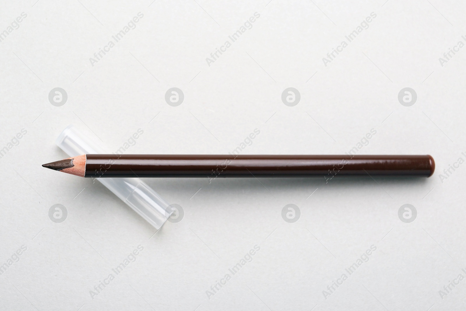 Brown eyebrow pencil on light background, top view Photo of Brown eyebrow pencil on light background, top view