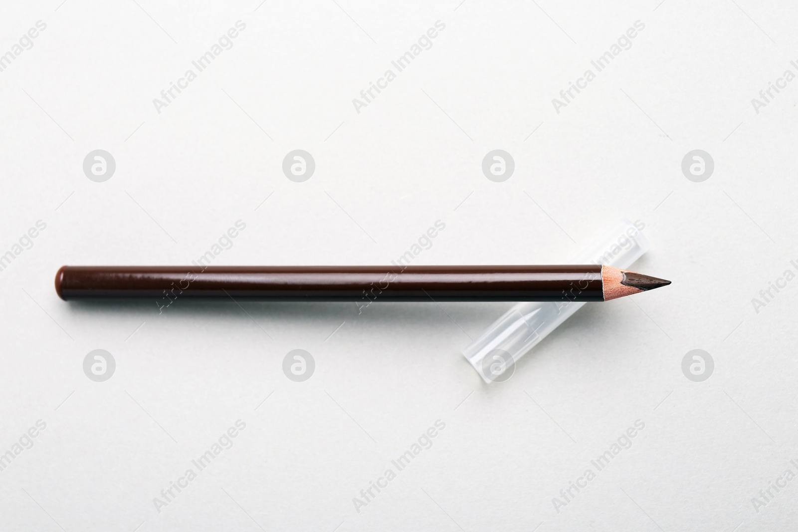 Brown eyebrow pencil on light background, top view Photo of Brown eyebrow pencil on light background, top view