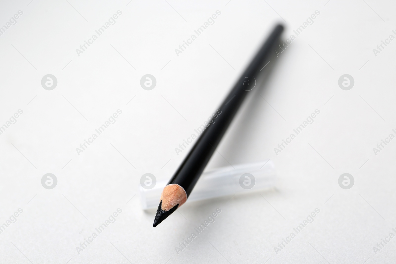 Black eyebrow pencil on light background, closeup. Space for text Photo of Black eyebrow pencil on light background, closeup. Space for text
