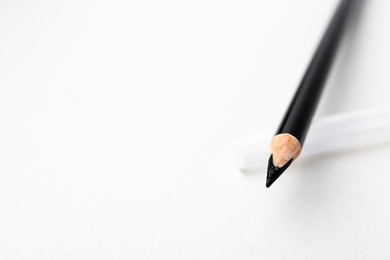 Photo of Black eyebrow pencil on light background, closeup. Space for text