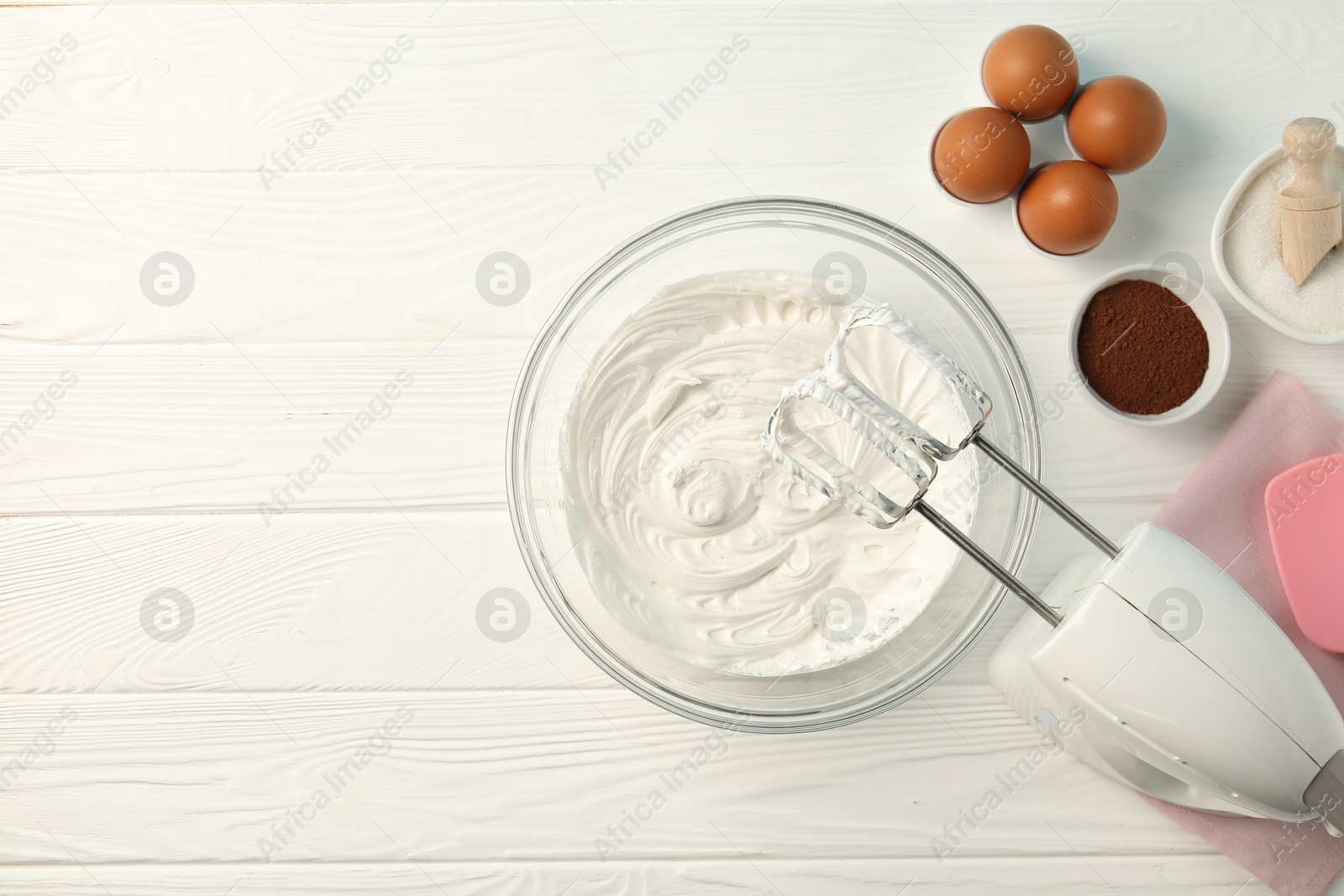 Bowl with whipped cream, hand mixer and ingredients on white wooden table, flat lay. Space for text Photo of Bowl with whipped cream, hand mixer and ingredients on white wooden table, flat lay. Space for text