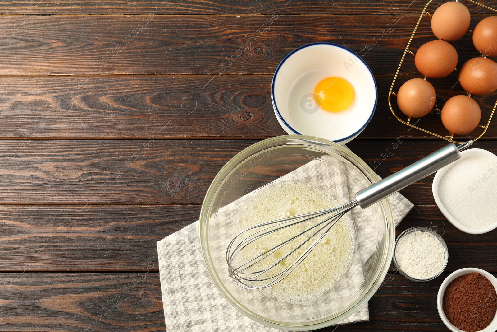 Making whipped cream. Bowl, whisk and ingredients on wooden table, flat lay. Space for text Photo of Making whipped cream. Bowl, whisk and ingredients on wooden table, flat lay. Space for text