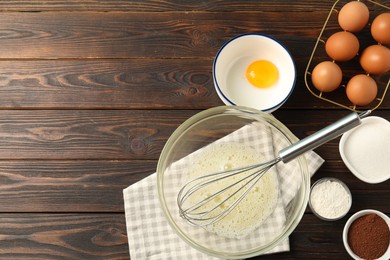 Photo of Making whipped cream. Bowl, whisk and ingredients on wooden table, flat lay. Space for text