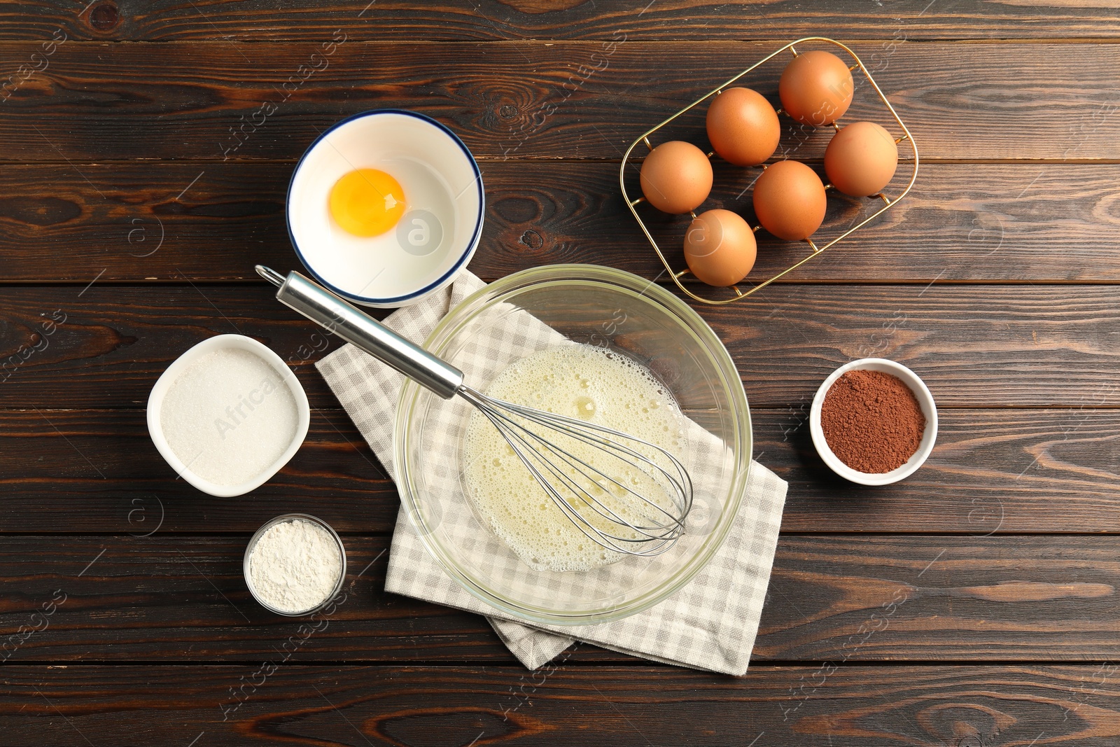 Making whipped cream. Bowl, whisk and ingredients on wooden table, flat lay Photo of Making whipped cream. Bowl, whisk and ingredients on wooden table, flat lay