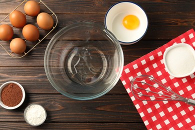 Photo of Making whipped cream. Bowl, whisk and ingredients on wooden table, flat lay
