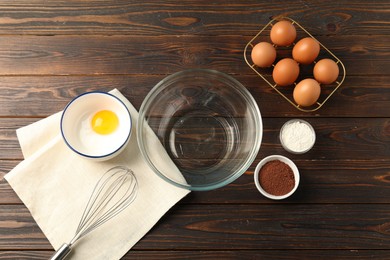 Photo of Making whipped cream. Bowl, whisk and ingredients on wooden table, flat lay