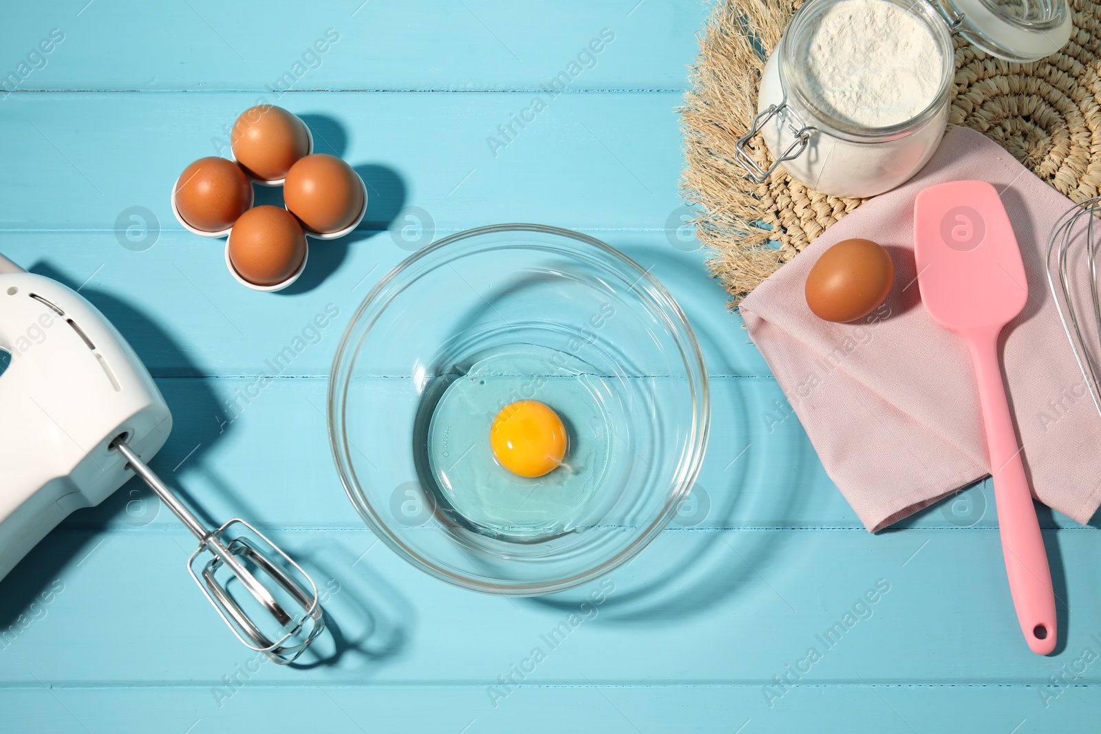 Making whipped cream. Bowl, hand mixer and ingredients on light blue wooden table, flat lay Photo of Making whipped cream. Bowl, hand mixer and ingredients on light blue wooden table, flat lay