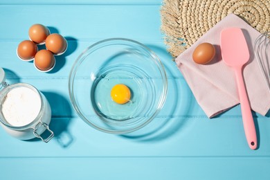 Photo of Making whipped cream. Bowl and ingredients on light blue wooden table, flat lay