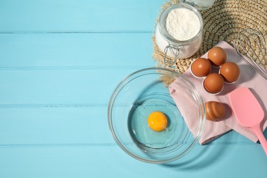 Photo of Making whipped cream. Bowl, whisk and ingredients on light blue wooden table, flat lay. Space for text