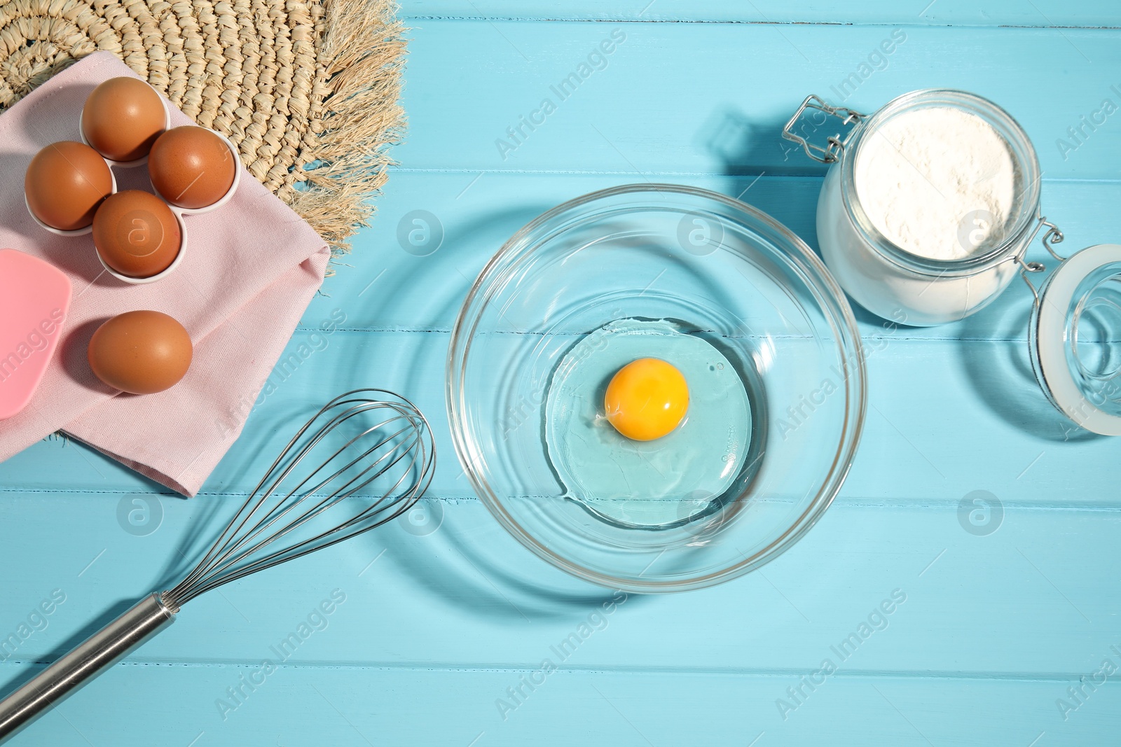 Making whipped cream. Bowl, whisk and ingredients on light blue wooden table, flat lay Photo of Making whipped cream. Bowl, whisk and ingredients on light blue wooden table, flat lay