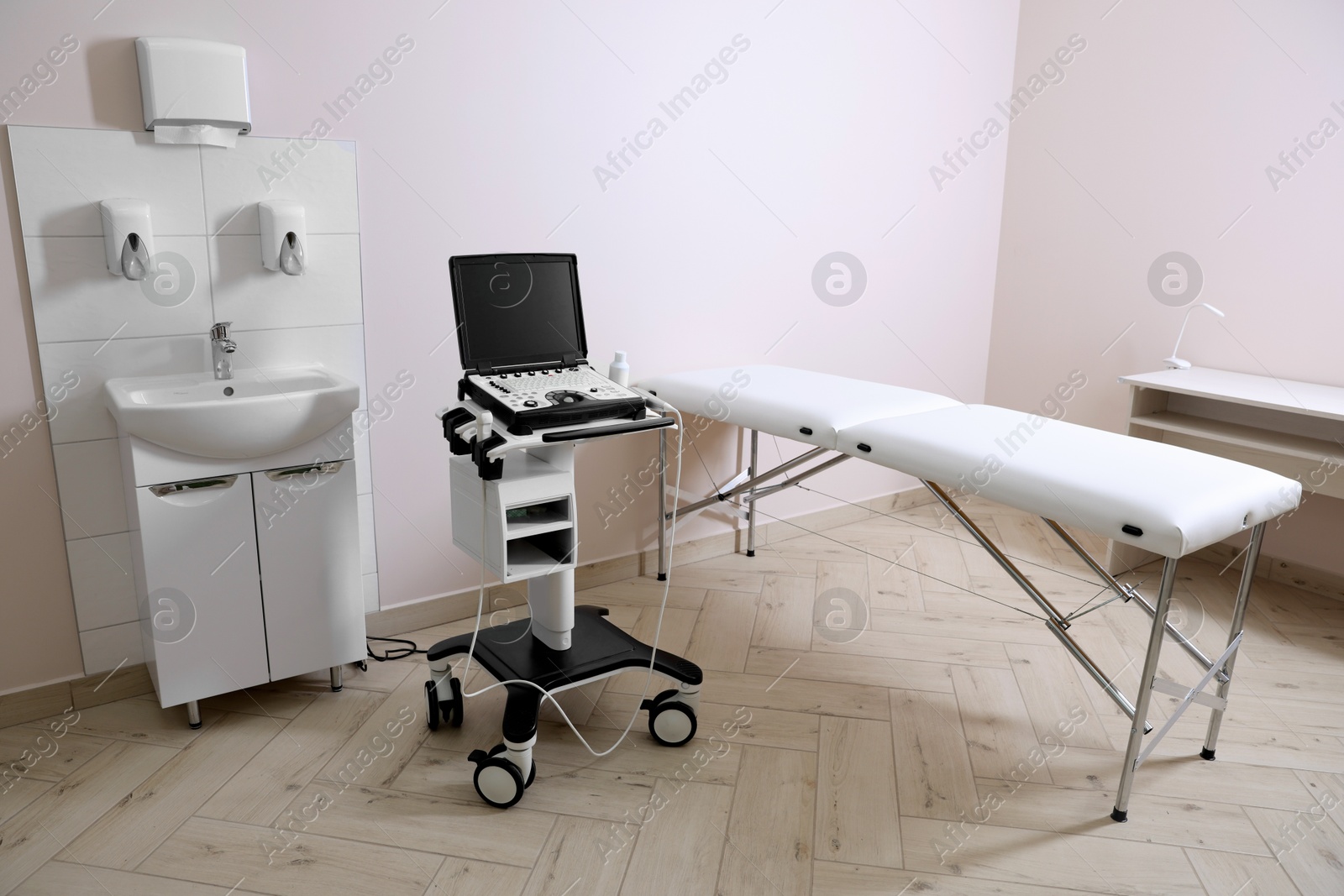 Modern ultrasound machine, sink and examination bed in clinic Photo of Modern ultrasound machine, sink and examination bed in clinic
