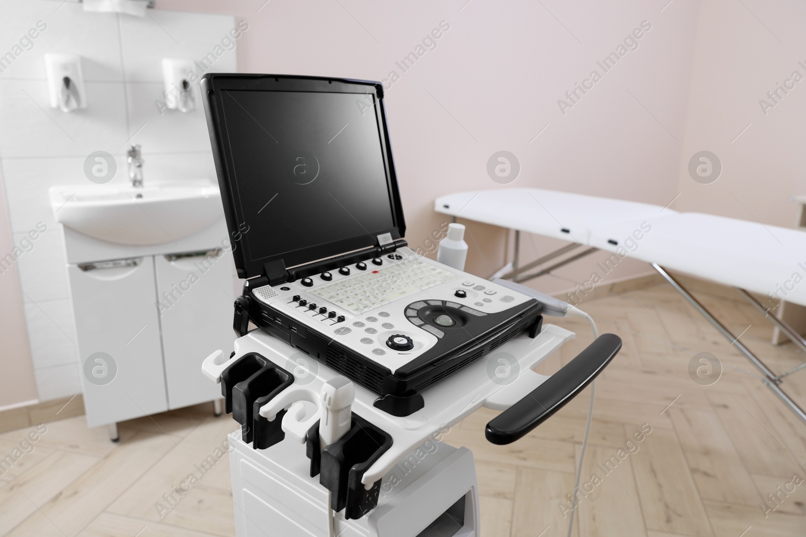 Modern ultrasound machine and examination bed in clinic Photo of Modern ultrasound machine and examination bed in clinic