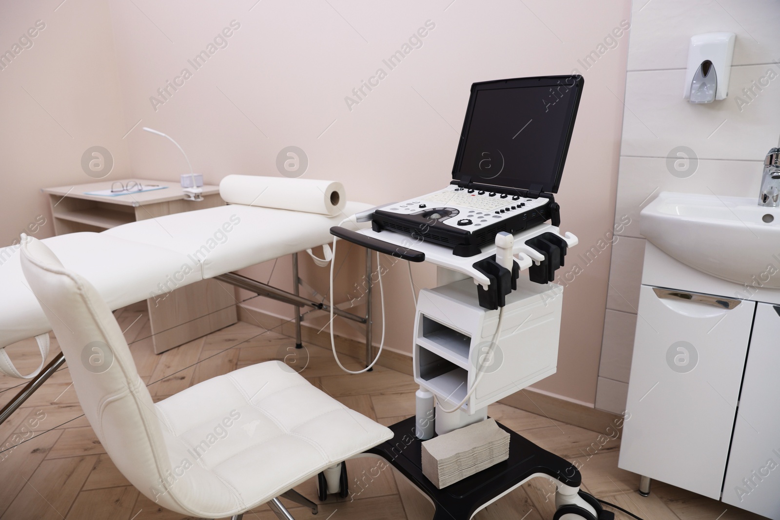 Modern ultrasound machine and examination bed in clinic Photo of Modern ultrasound machine and examination bed in clinic
