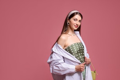 Photo of Fashionable portrait of beautiful woman in stylish outfit on pink background. Space for text