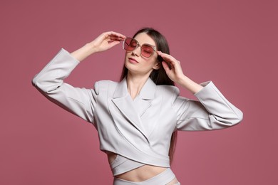 Photo of Fashionable portrait of beautiful woman in stylish outfit on pink background