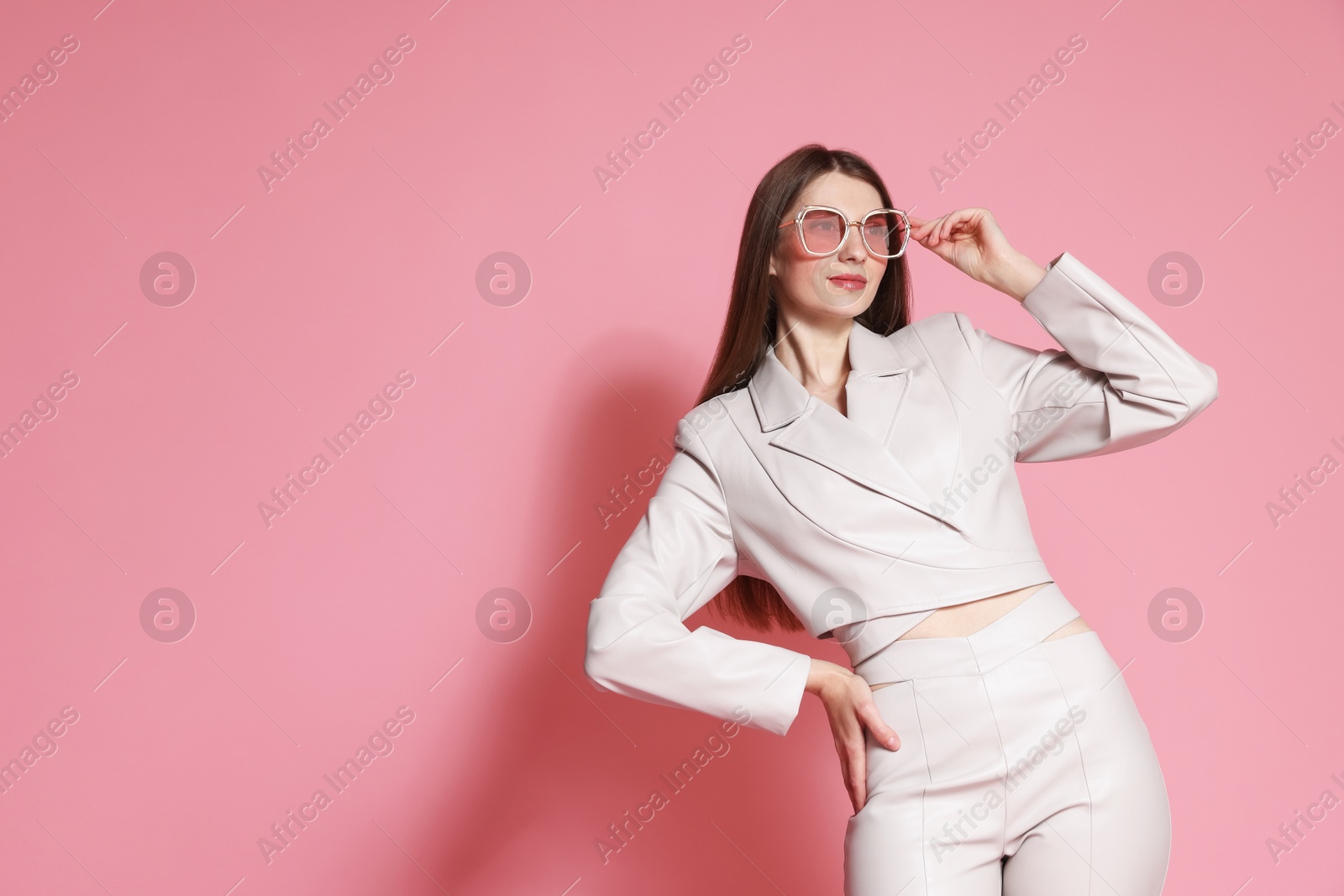Fashionable portrait of beautiful woman in stylish outfit on pink background. Space for text Photo of Fashionable portrait of beautiful woman in stylish outfit on pink background. Space for text